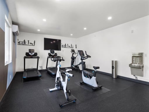 a room with a lot of exercise equipment and a tv on the wall at Enclave, Paramount, 90723