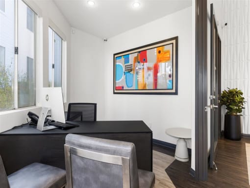 a room with a desk and two chairs and a painting on the wall at Enclave, Paramount 