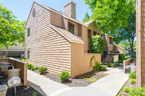 a side view of a house with stairs and a sidewalk