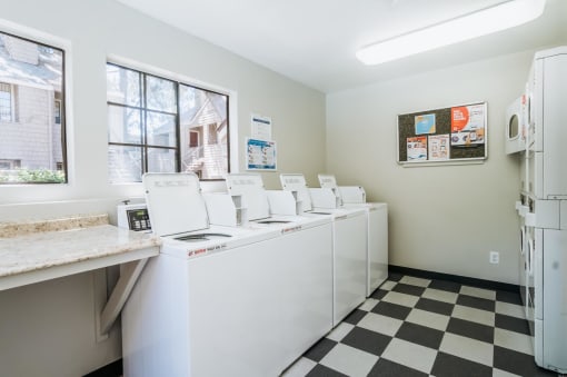 a laundry room with washers and dryers and a checkered floor