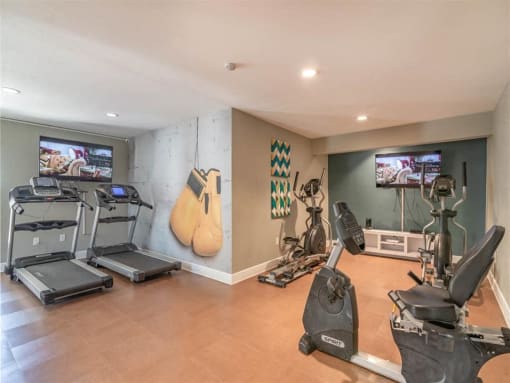 a home gym with cardio equipment and guitars on the wall