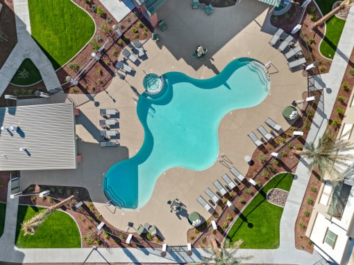 an aerial view of a swimming pool at a resort with umbrellas