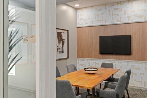 a conference room with a wooden table and a television