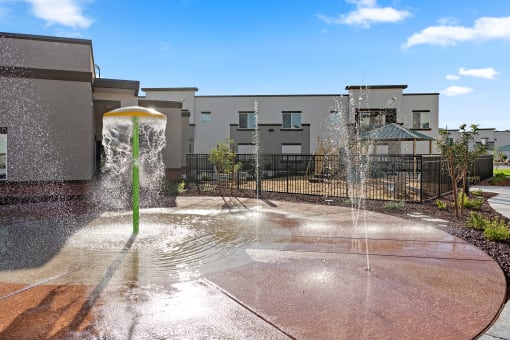 a fountain in a courtyard with buildings in the background