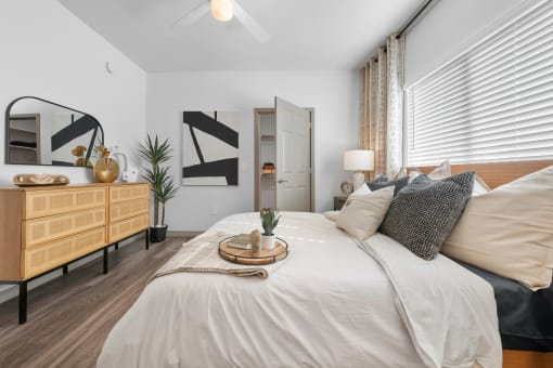 a bedroom with a large bed with white sheets and pillows