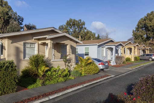 a row of houses with cars parked in front of them