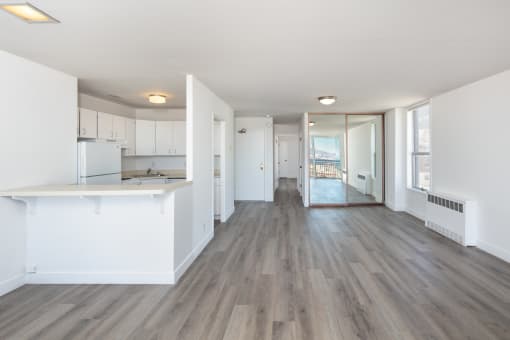 an empty apartment with white walls and hardwood floors