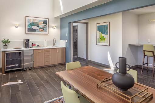 a dining room with a table and chairs and a kitchen with a sink