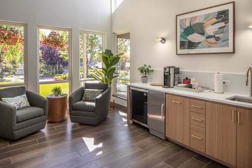 a kitchen with a sink and chairs and a window