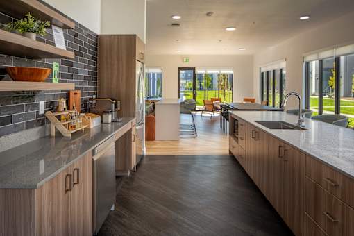 A modern kitchen with wooden cabinets and a large island at The Arvon, Vancouver