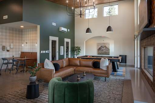 A living room with a pool table and a green couch.