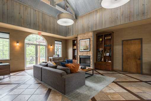A living room with a grey couch and a fireplace.