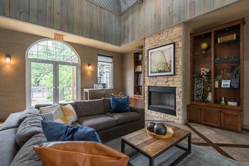 A living room with a grey couch and a fireplace.