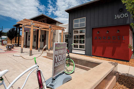 A bicycle is parked in front of a sign that says "REFRESH YOUR ADDRESS" in front of a building with a red door.