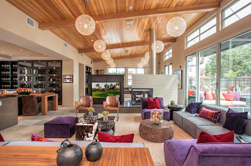 A living room with a purple couch and a wooden table.