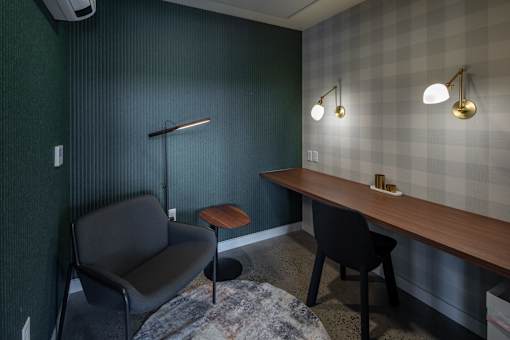 A room with a chair, a table, and a lamp.