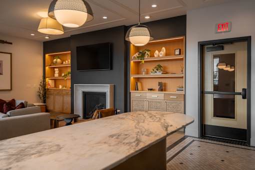 A modern kitchen with a marble countertop and a fireplace.