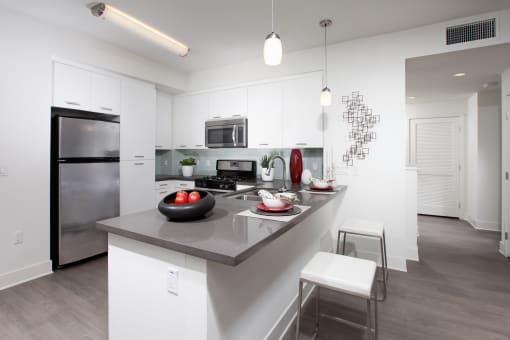 a kitchen with white cabinetry and an island with a gray countertop