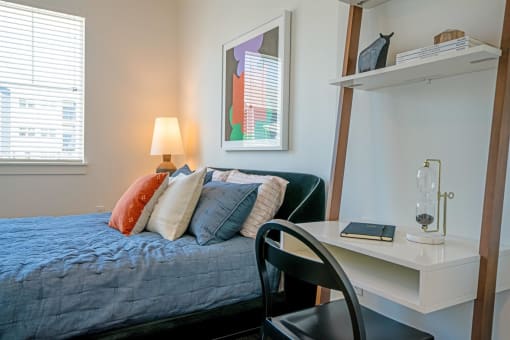 a bedroom with a bed and a desk with a chair