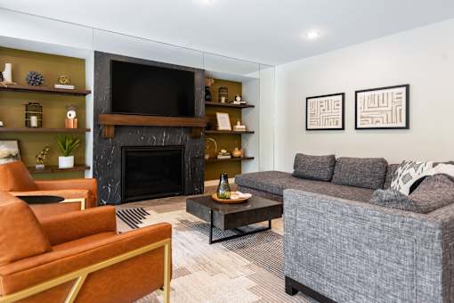 A living room with a grey couch, a fireplace, and a television.