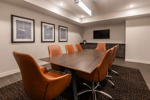A conference room with a long table and chairs.