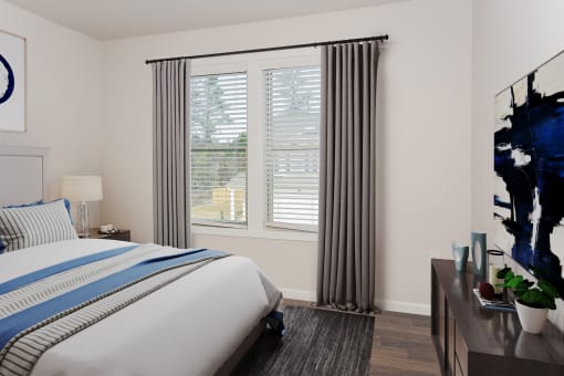 a bedroom with a large window and a bed with a blue and white striped comforter