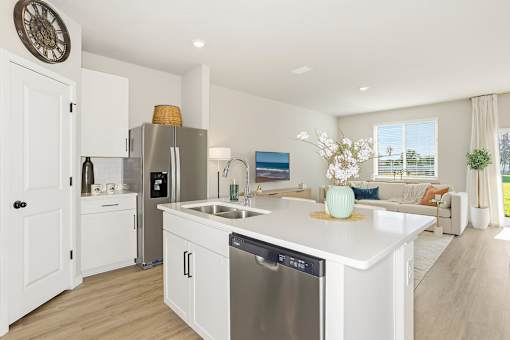 A modern kitchen with a large island and stainless steel appliances at Coral Palms at Oakleaf homes for rent in Middleburg, FL.