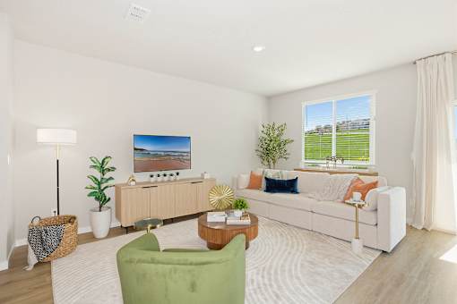 A living room with a white couch, a green chair, and a wooden coffee table at Coral Palms at Oakleaf townhomes for rent in Middleburg.