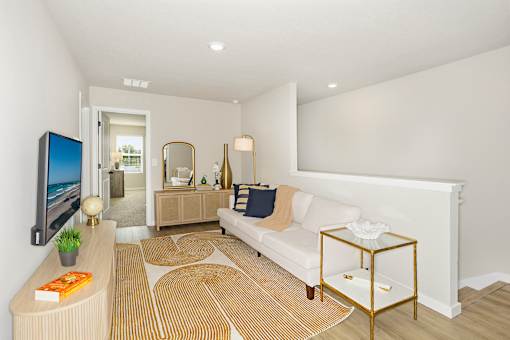 A living room with a white couch, a television, and a coffee table.