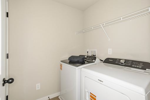 A small laundry room with a washer and dryer.