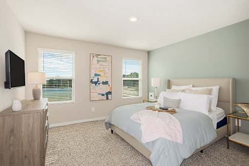 A bedroom with a bed, nightstand, and a painting on the wall.
