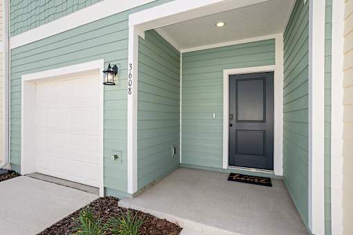 An exterior view of a garage and a front door at Coral Palms at Oakleaf townhomes in Middleburg.