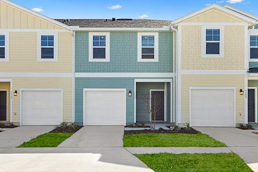 A row of houses with garages and driveways at Coral Palms at Oakleaf homes for rent in Middleburg, FL.