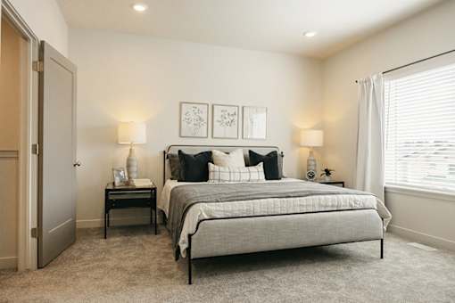A bedroom with a large bed and two nightstands.
