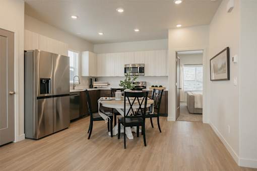 A kitchen with a table and chairs in the middle of the room.