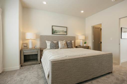 A bedroom with a large bed and a small fireplace.
