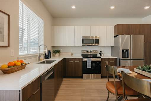 A modern kitchen with a refrigerator, sink, and stove.