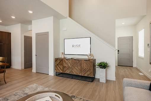 A living room with a wooden cabinet and a TV on top of it.