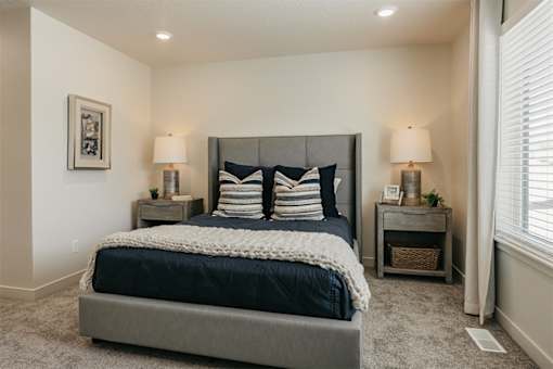 A bedroom with a large bed and two nightstands.