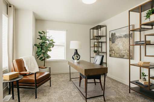 A room with a brown leather chair and a wooden table.