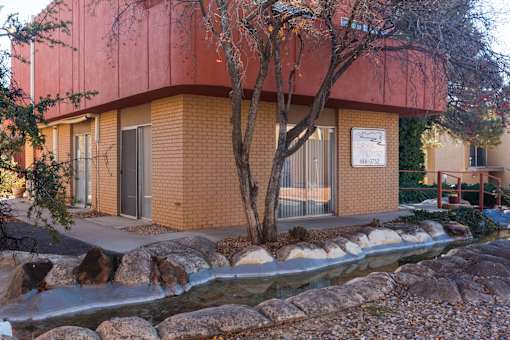 A building with a red roof and a tree in front of it.