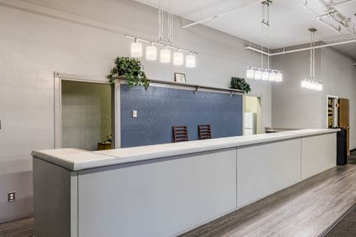 A modern office space with a long white counter and a blue backdrop.