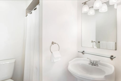 a bathroom with a white sink and a white shower curtain