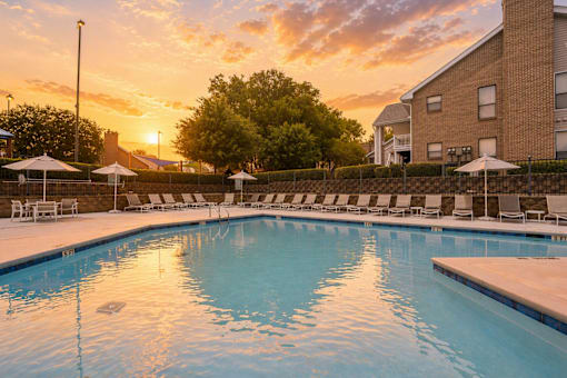 A swimming pool with sunset in the background.