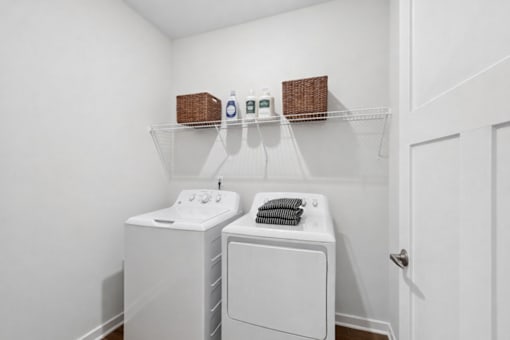 A white laundry room with a washer and dryer.