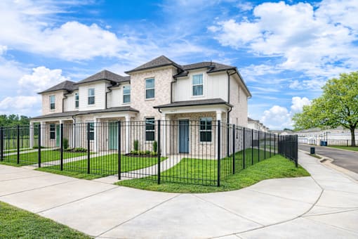 A row of houses with black fences in front.