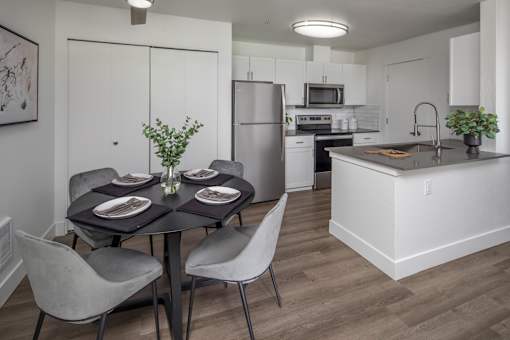 A modern kitchen with a dining table set for two.
