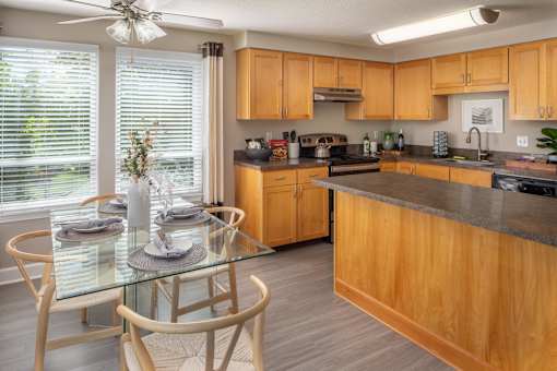 a kitchen with wooden cabinets and a table with chairs