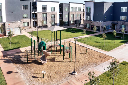 an outdoor playground is shown in front of an apartment building