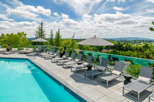 a pool with lounge chairs and umbrellas at Arbor Heights, Oregon